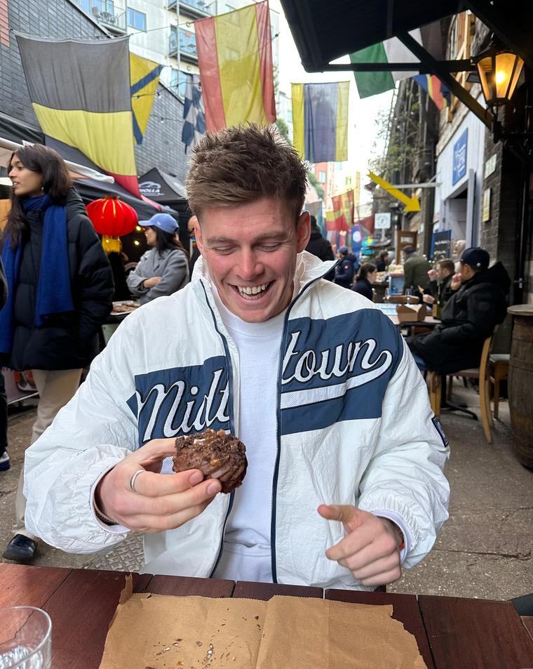 Paddy eating a cookie at a busy outdoor table